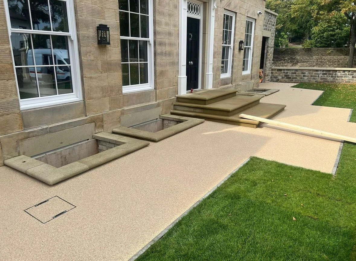 Light resin garden paths alongside a lawn and stone house